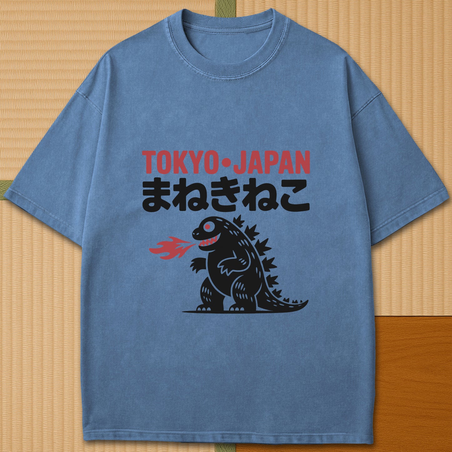 Japanese-inspired cotton Maneki Neko Monster T-Shirt in Blue Jean on Comfort Colors 1717, styled in a modern flatlay scene.