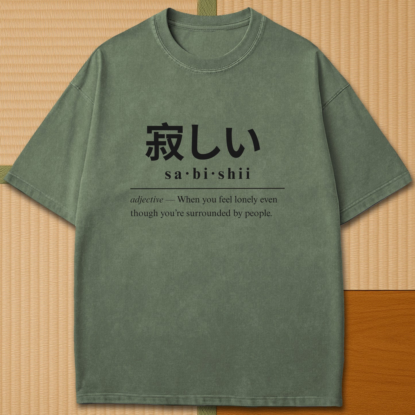 Japanese-inspired cotton Sabishii Japanese Dictionary T-Shirt in Moss on Comfort Colors 1717, styled in a modern flatlay scene.