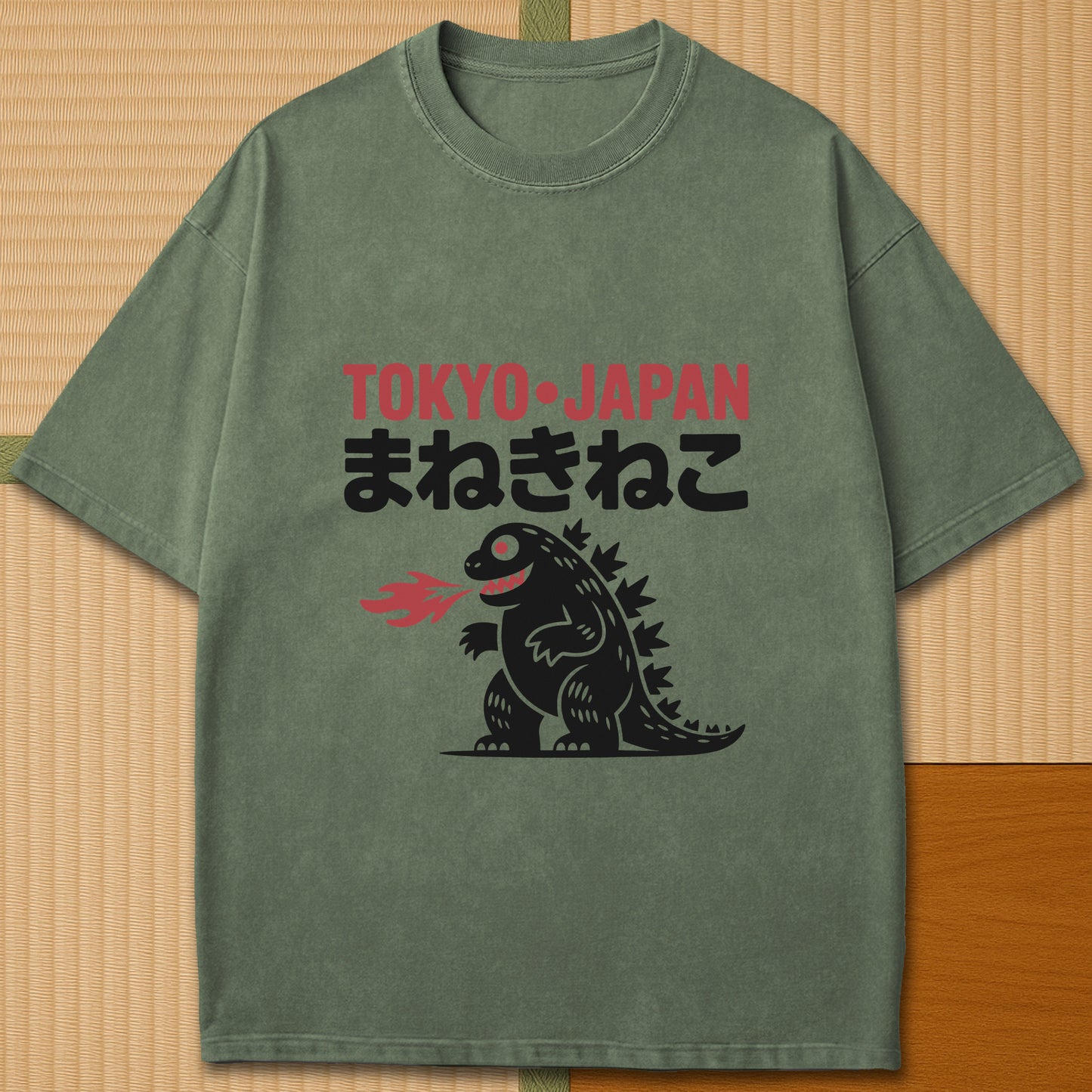 Japanese-inspired cotton Maneki Neko Monster T-Shirt in Moss on Comfort Colors 1717, styled in a modern flatlay scene.