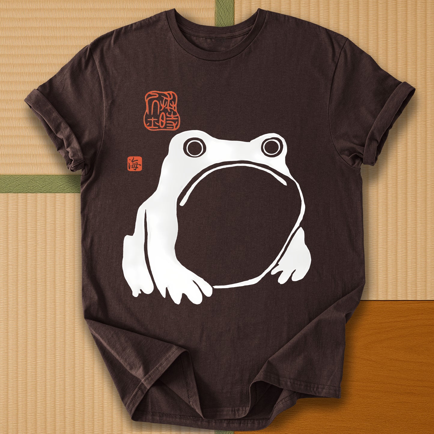 Japanese-inspired cotton Frowning Frog Print T-Shirt in Dark Chocolate on Gildan 64000, styled in a modern flatlay scene