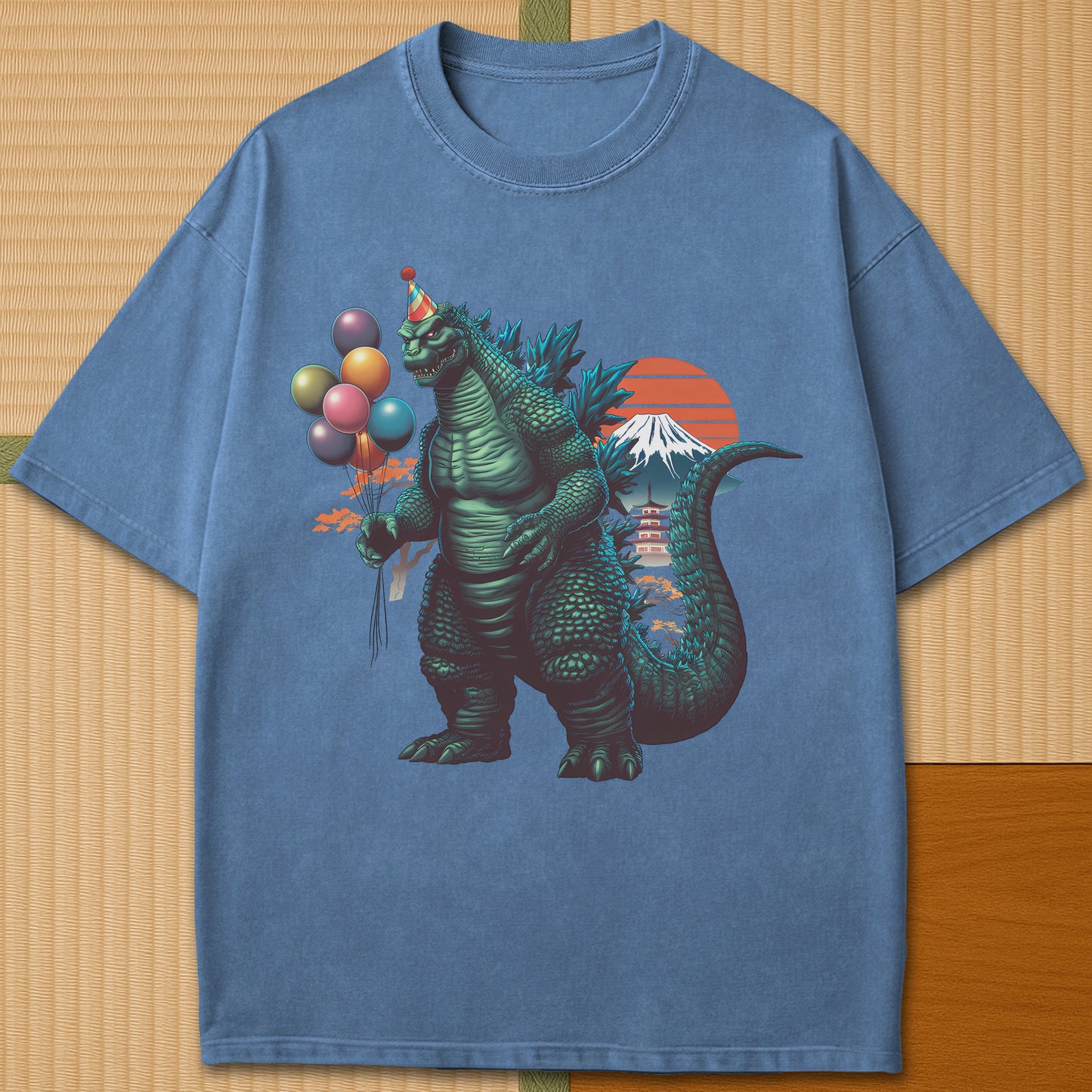 Japanese-inspired cotton Birthday Kaiju T-Shirt in Blue Jean on Comfort Colors 1717, styled in a modern flatlay scene.