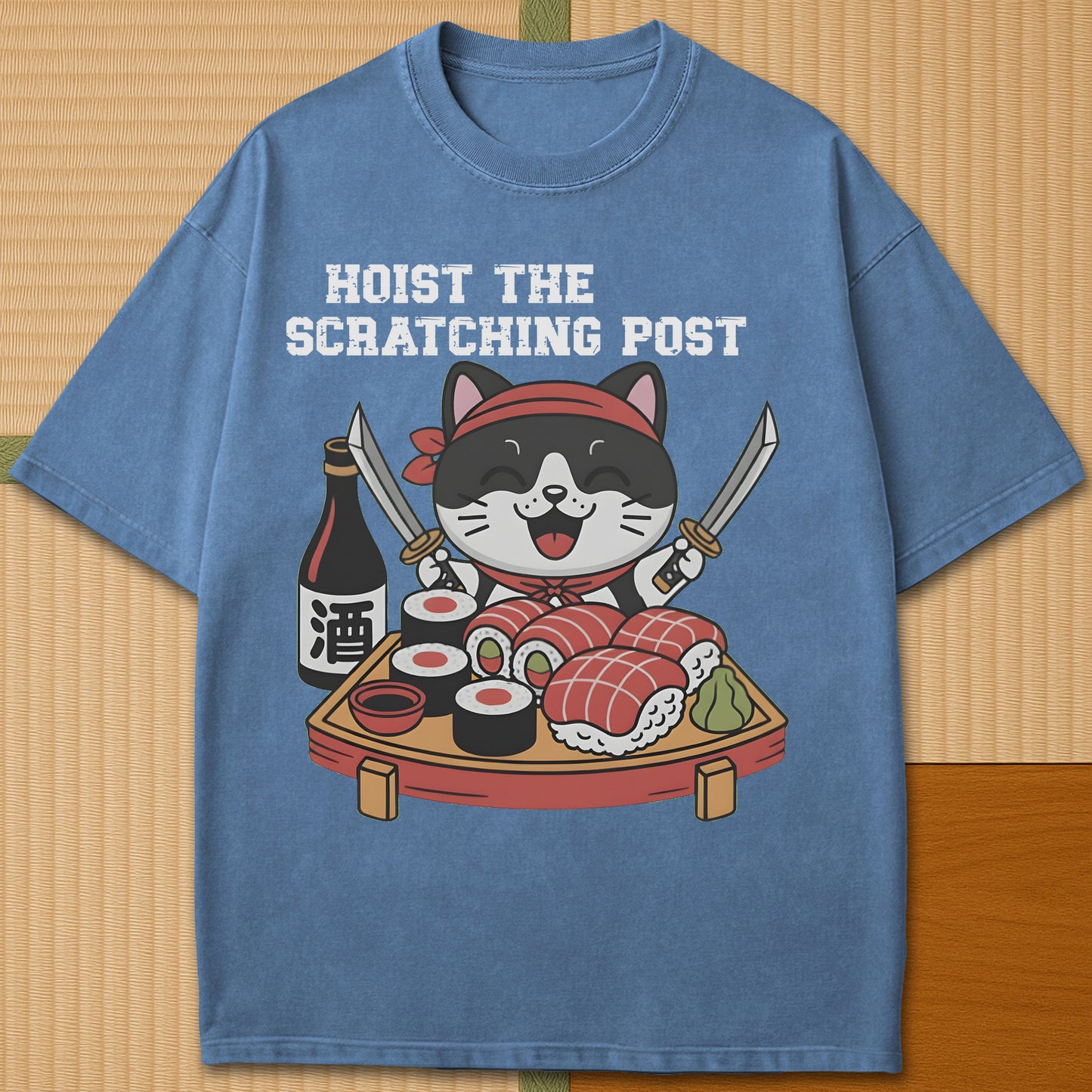 Japanese-inspired cotton Sushi Pirate Hoist The Scratching Post T-Shirt in Blue Jean on Comfort Colors 1717, styled in a modern flatlay scene.