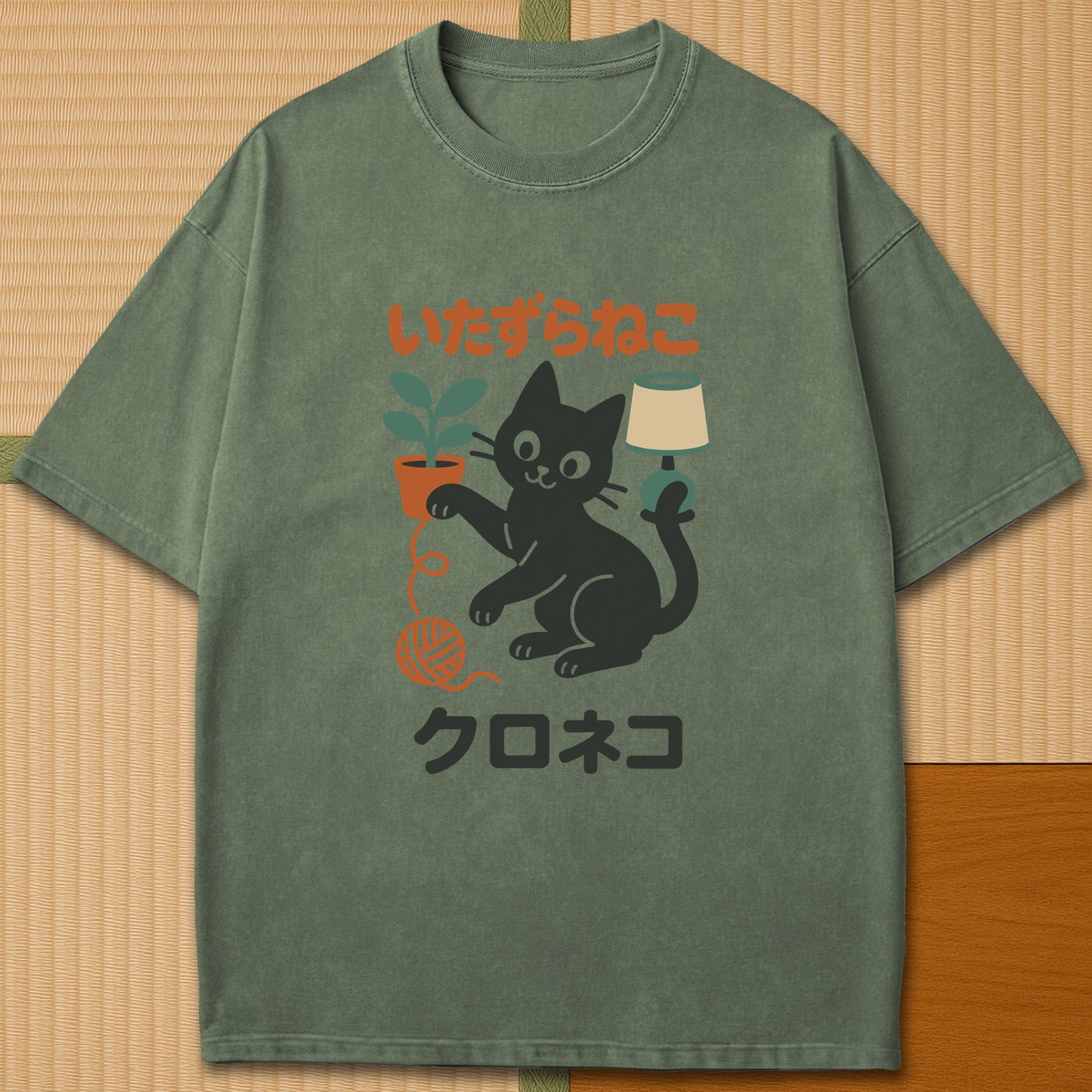 Japanese-inspired cotton Mischievous Black Cat T-Shirt in Moss on Comfort Colors 1717, styled in a modern flatlay scene.