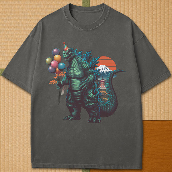 Japanese-inspired cotton Birthday Kaiju T-Shirt in Pepper on Comfort Colors 1717, styled in a modern flatlay scene.