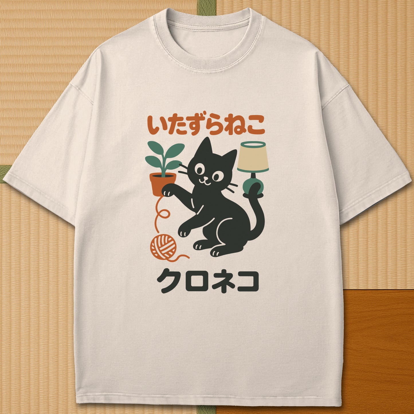 Japanese-inspired cotton Mischievous Black Cat T-Shirt in Ivory on Comfort Colors 1717, styled in a modern flatlay scene.