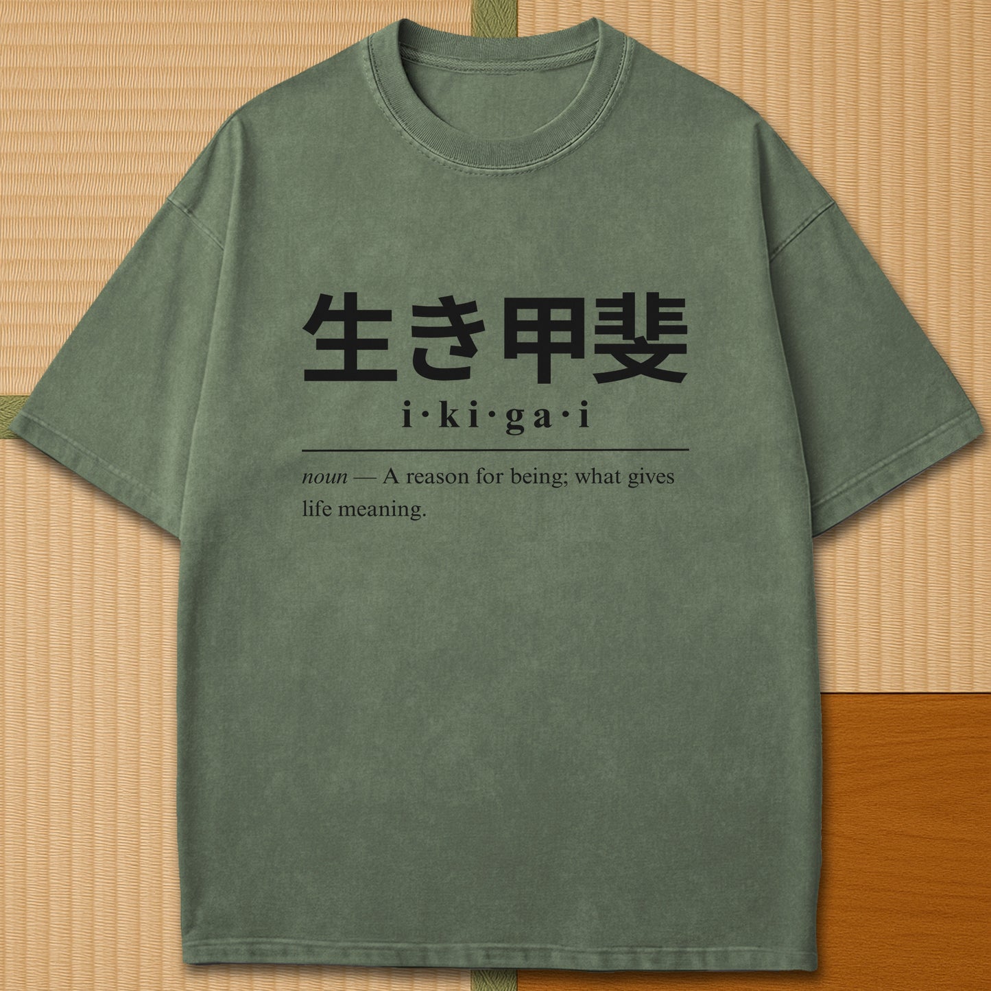 Japanese-inspired cotton Ikigai Japanese Dictionary T-Shirt in Moss on Comfort Colors 1717, styled in a modern flatlay scene.