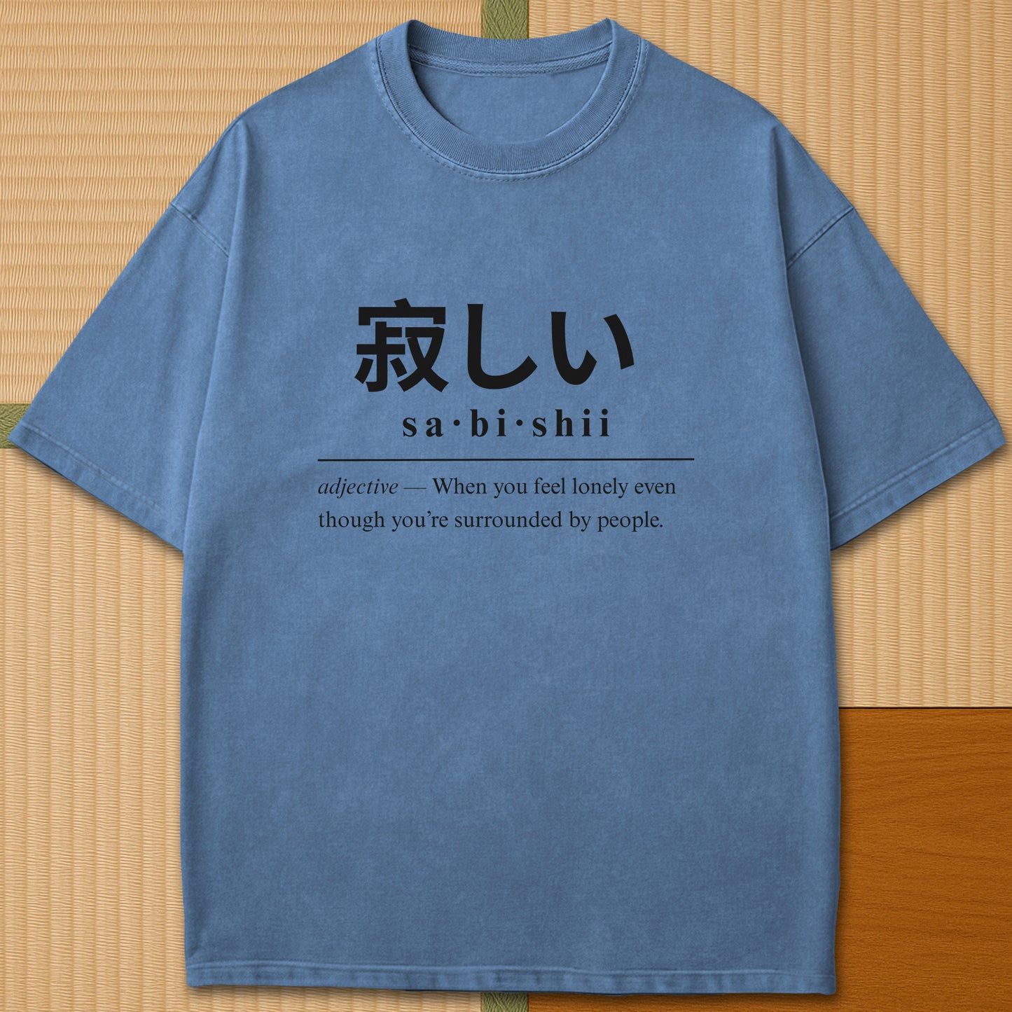 Japanese-inspired cotton Sabishii Japanese Dictionary T-Shirt in Blue Jean on Comfort Colors 1717, styled in a modern flatlay scene.