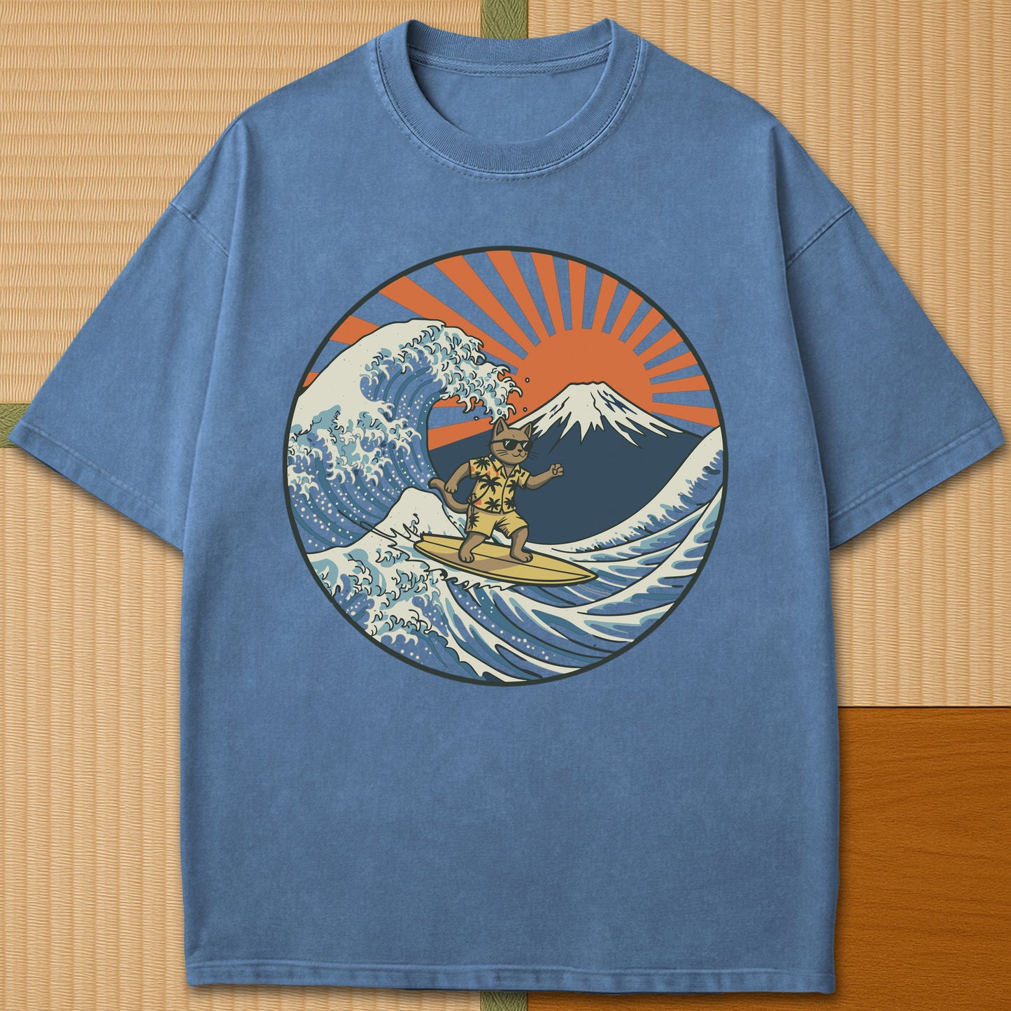 Japanese-inspired cotton Surfing Neko Retro Wave Cat Vs Mt Fuji Sunset T-Shirt in Blue Jean on Comfort Colors 1717, styled in a modern flatlay scene.