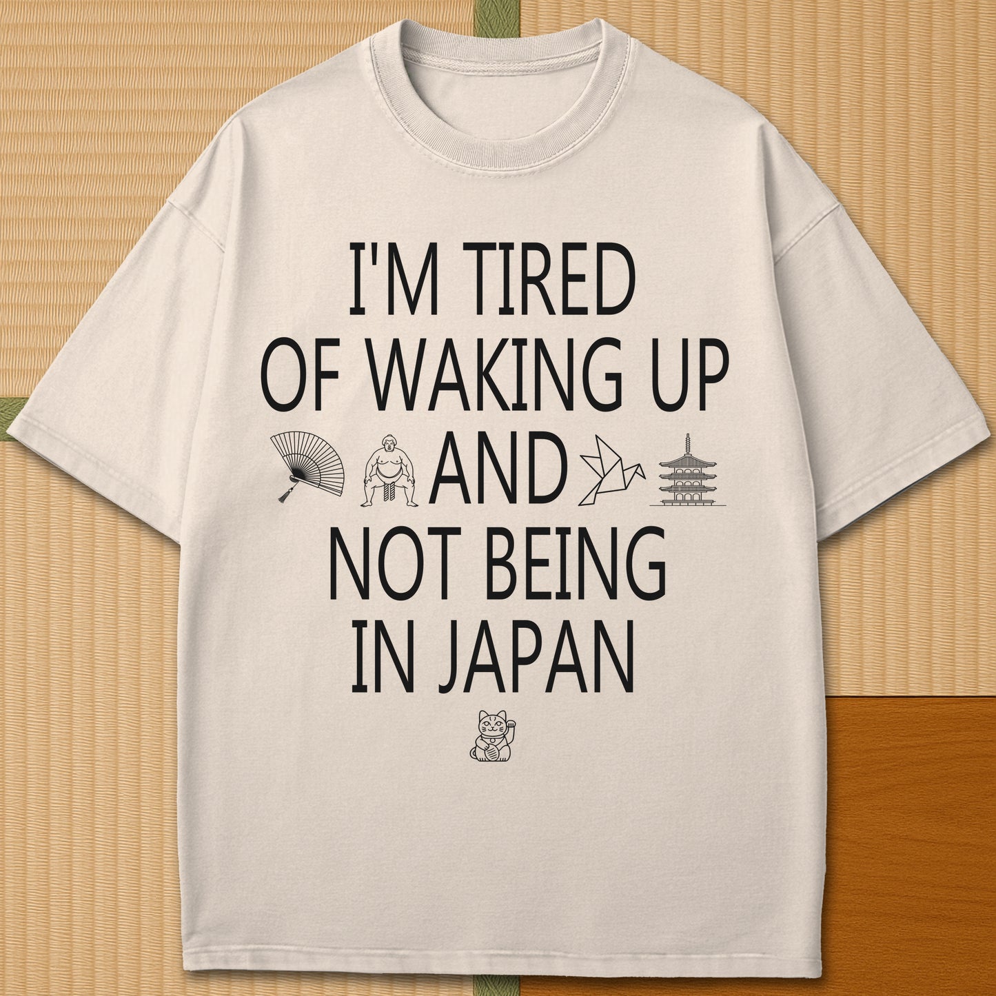 Japanese-inspired cotton Tired Waking Up Not In Japan T-Shirt in Ivory on Comfort Colors 1717, styled in a modern flatlay scene.