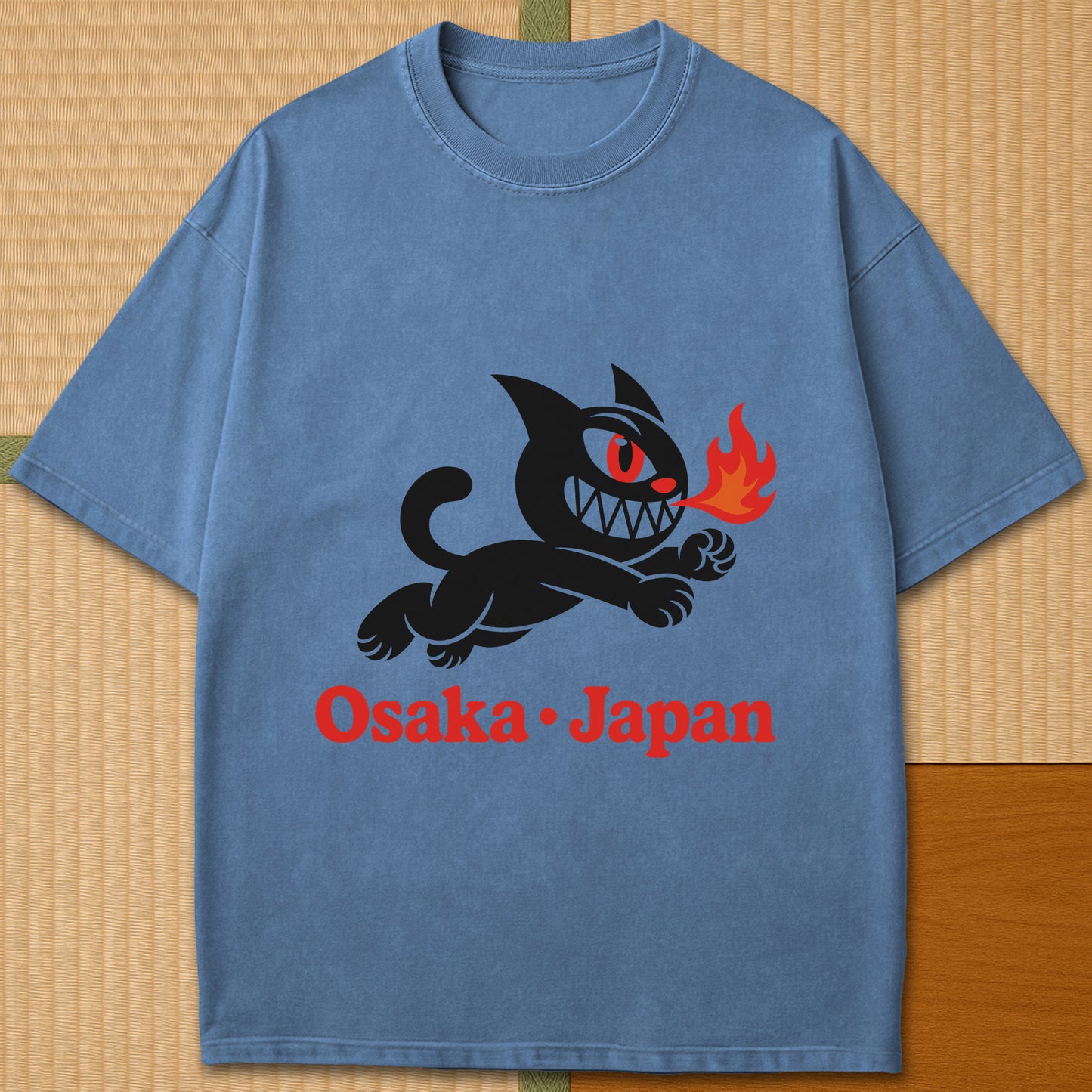 Japanese-inspired cotton Mischievous Cat Osaka T-Shirt in Blue Jean on Comfort Colors 1717, styled in a modern flatlay scene.