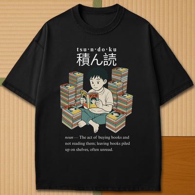 Japanese-inspired cotton Tsundoku Boy Manga Collector T-Shirt in Black on Comfort Colors 1717, styled in a modern flatlay scene.