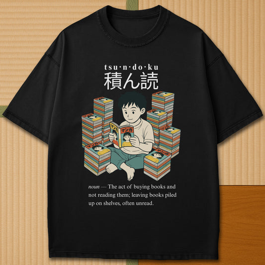 Japanese-inspired cotton Tsundoku Boy Manga Collector T-Shirt in Black on Comfort Colors 1717, styled in a modern flatlay scene.