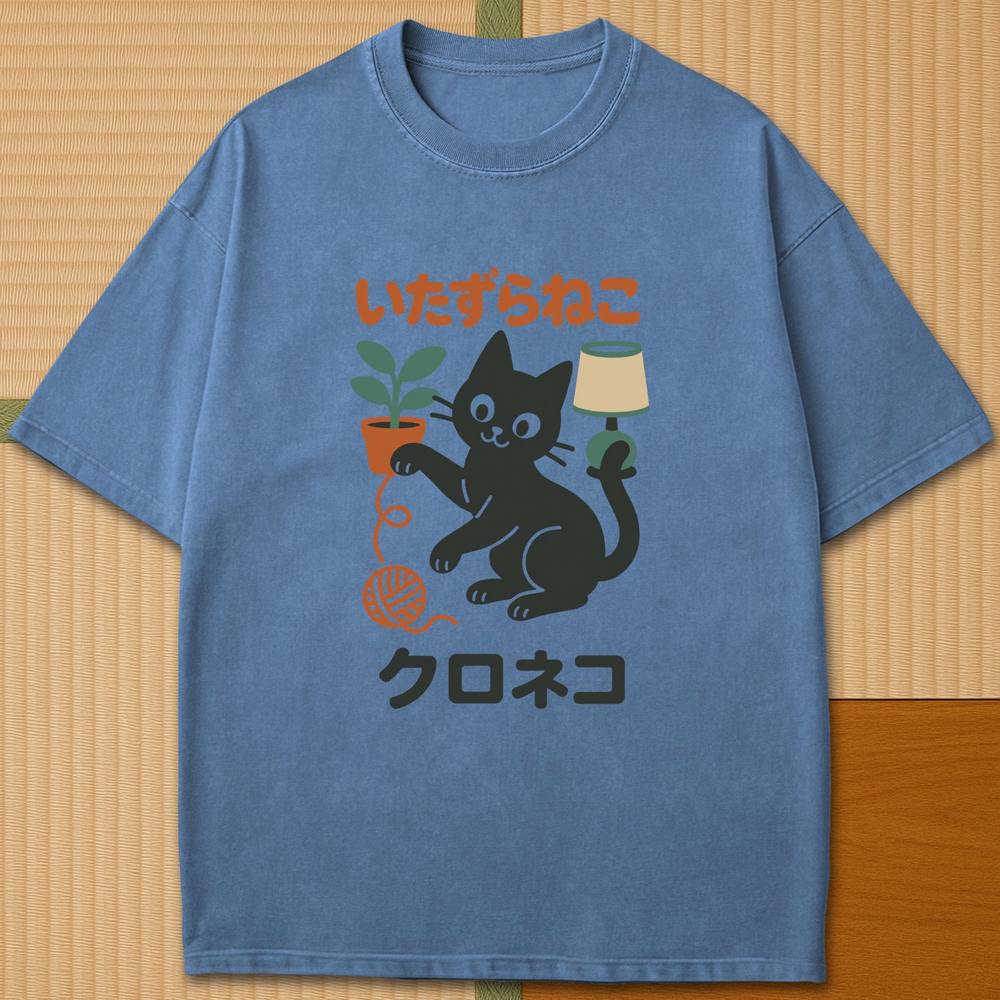 Japanese-inspired cotton Mischievous Black Cat T-Shirt in Blue Jean on Comfort Colors 1717, styled in a modern flatlay scene.