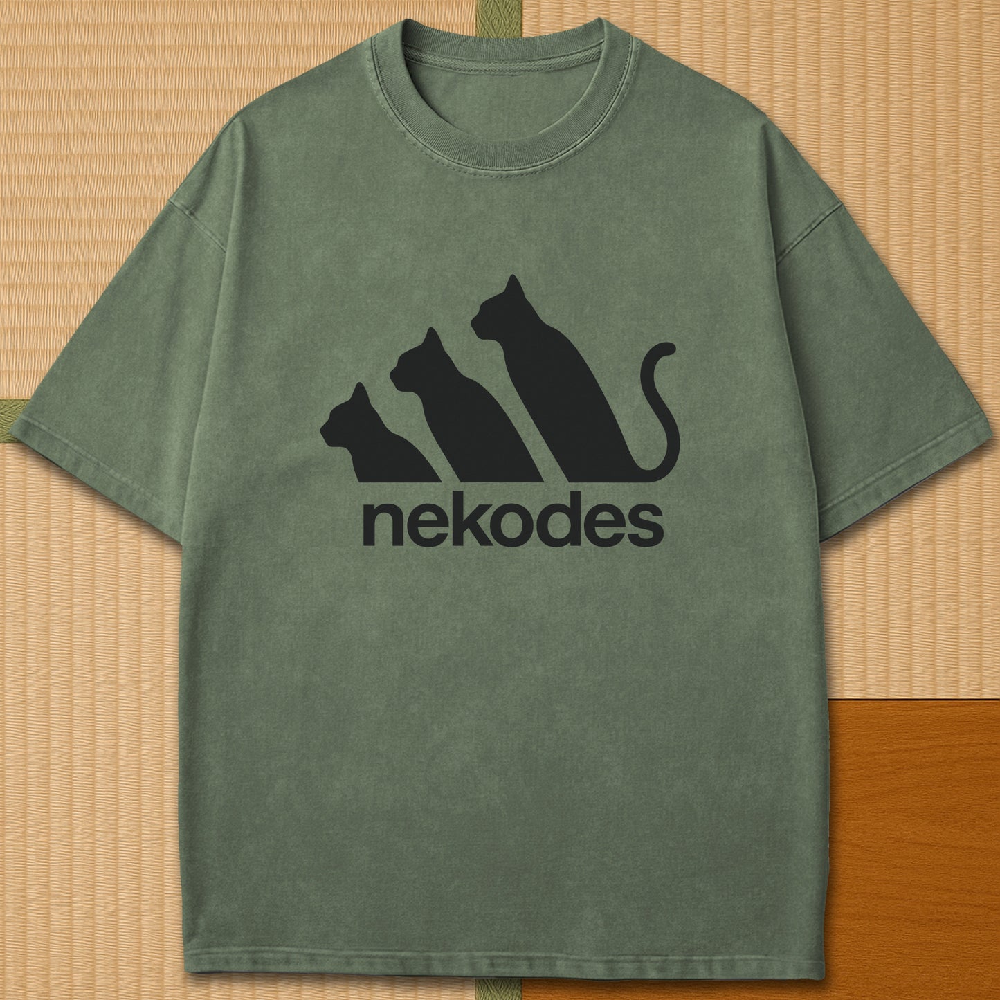 Japanese-inspired cotton Nekodes T-Shirt in Moss on Comfort Colors 1717, styled in a modern flatlay scene.