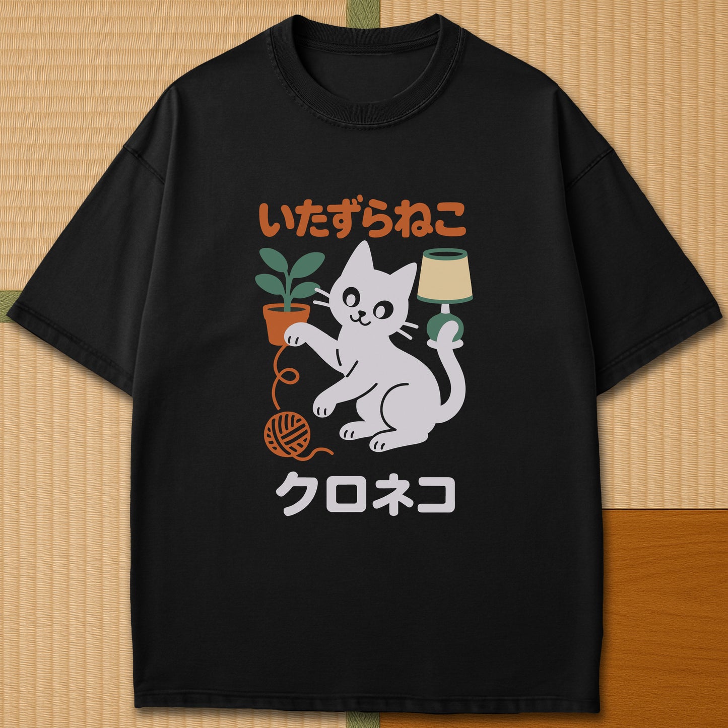 Japanese-inspired cotton Mischievous Black Cat T-Shirt in Black on Comfort Colors 1717, styled in a modern flatlay scene.