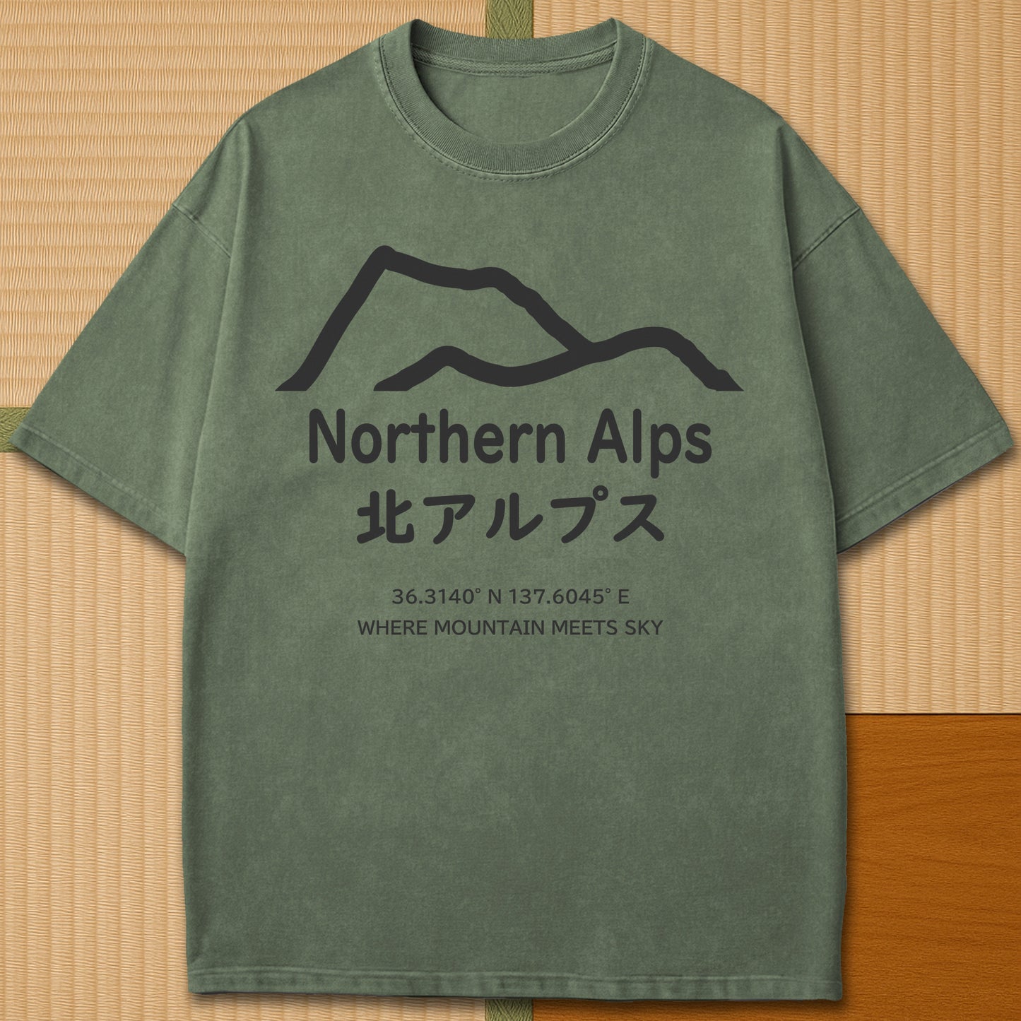 Japanese-inspired cotton Northern Alps Japan T-Shirt in Moss on Comfort Colors 1717, styled in a modern flatlay scene.