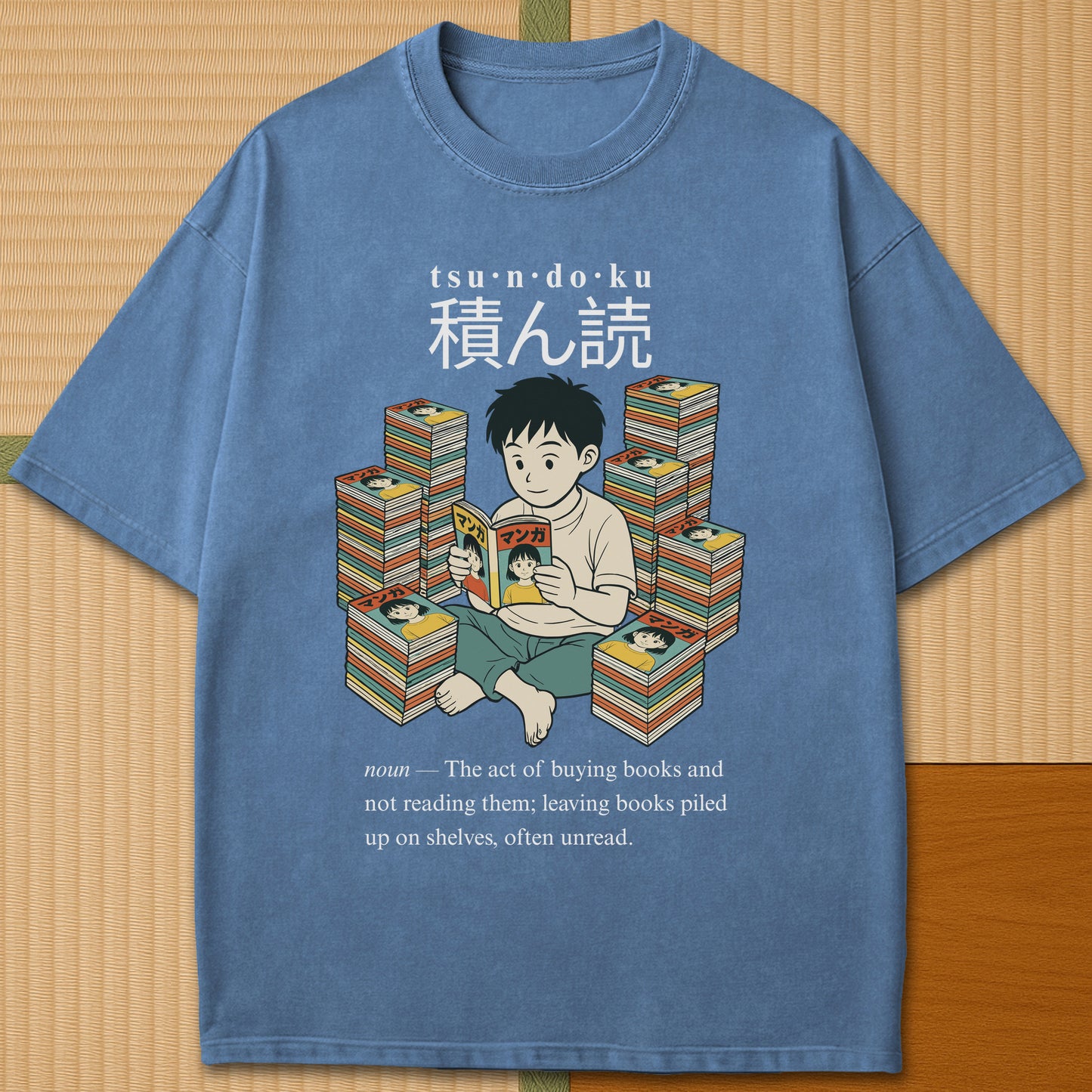 Japanese-inspired cotton Tsundoku Boy Manga Collector T-Shirt in Blue Jean on Comfort Colors 1717, styled in a modern flatlay scene.