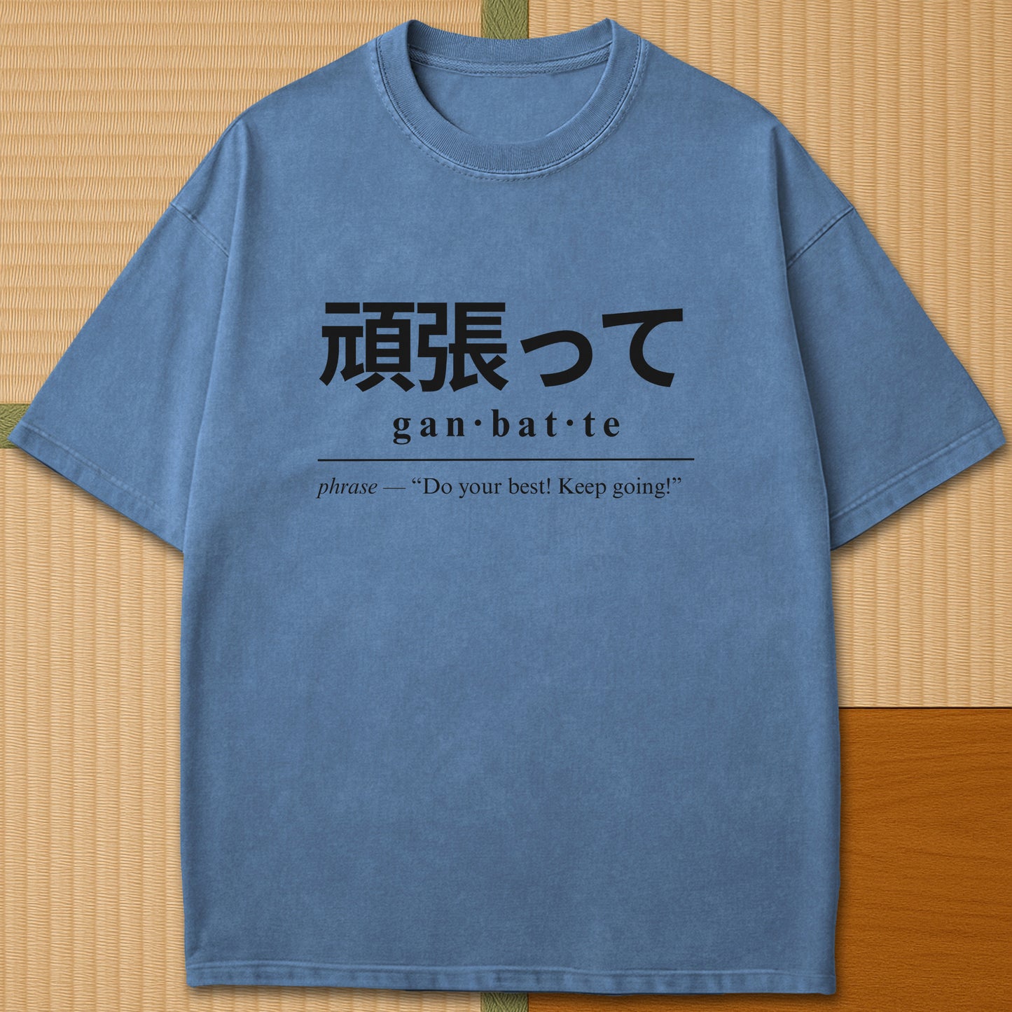 Japanese-inspired cotton Ganbatte Japanese Dictionary T-Shirt in Blue Jean on Comfort Colors 1717, styled in a modern flatlay scene.