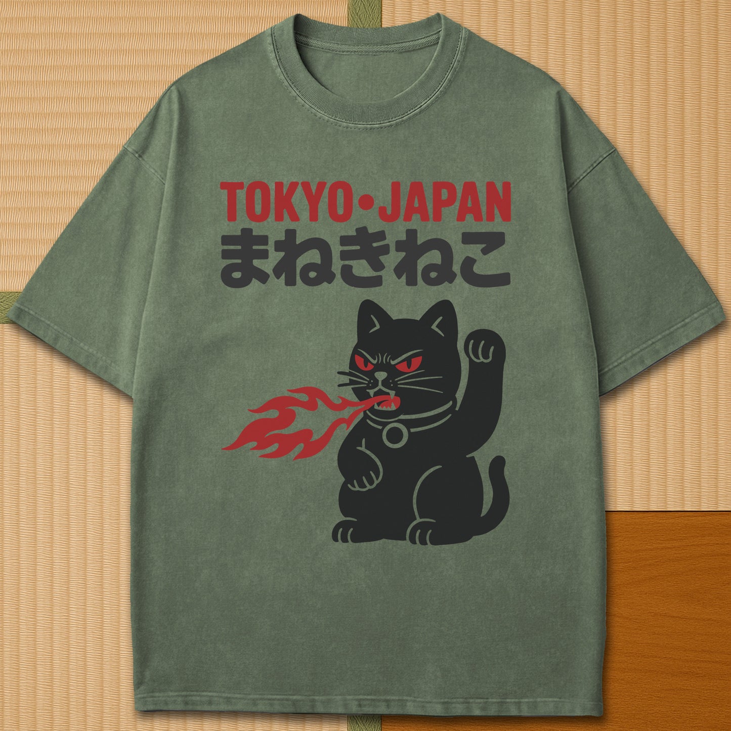 Japanese-inspired cotton Maneki Neko Monster T-Shirt in Moss on Comfort Colors 1717, styled in a modern flatlay scene.