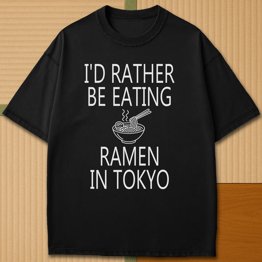 Japanese-inspired cotton Rather Be Eating Ramen T-Shirt in Black on Comfort Colors 1717, styled in a modern flatlay scene.