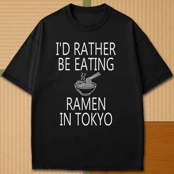 Japanese-inspired cotton Rather Be Eating Ramen T-Shirt in Black on Comfort Colors 1717, styled in a modern flatlay scene.