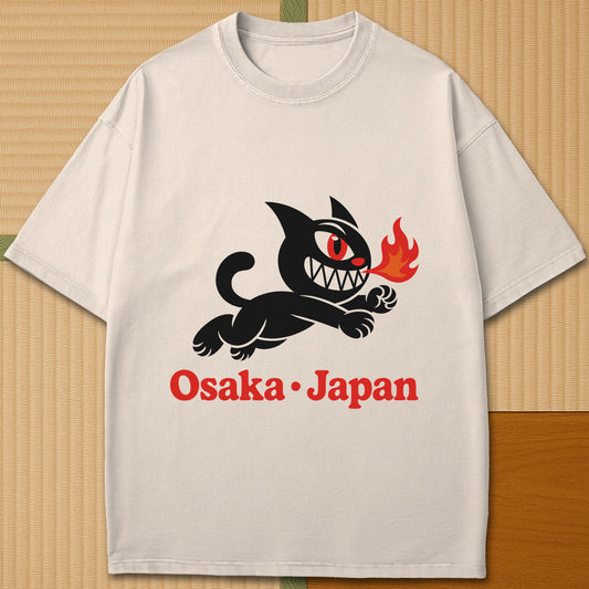Japanese-inspired cotton Mischievous Cat Osaka T-Shirt in Ivory on Comfort Colors 1717, styled in a modern flatlay scene.