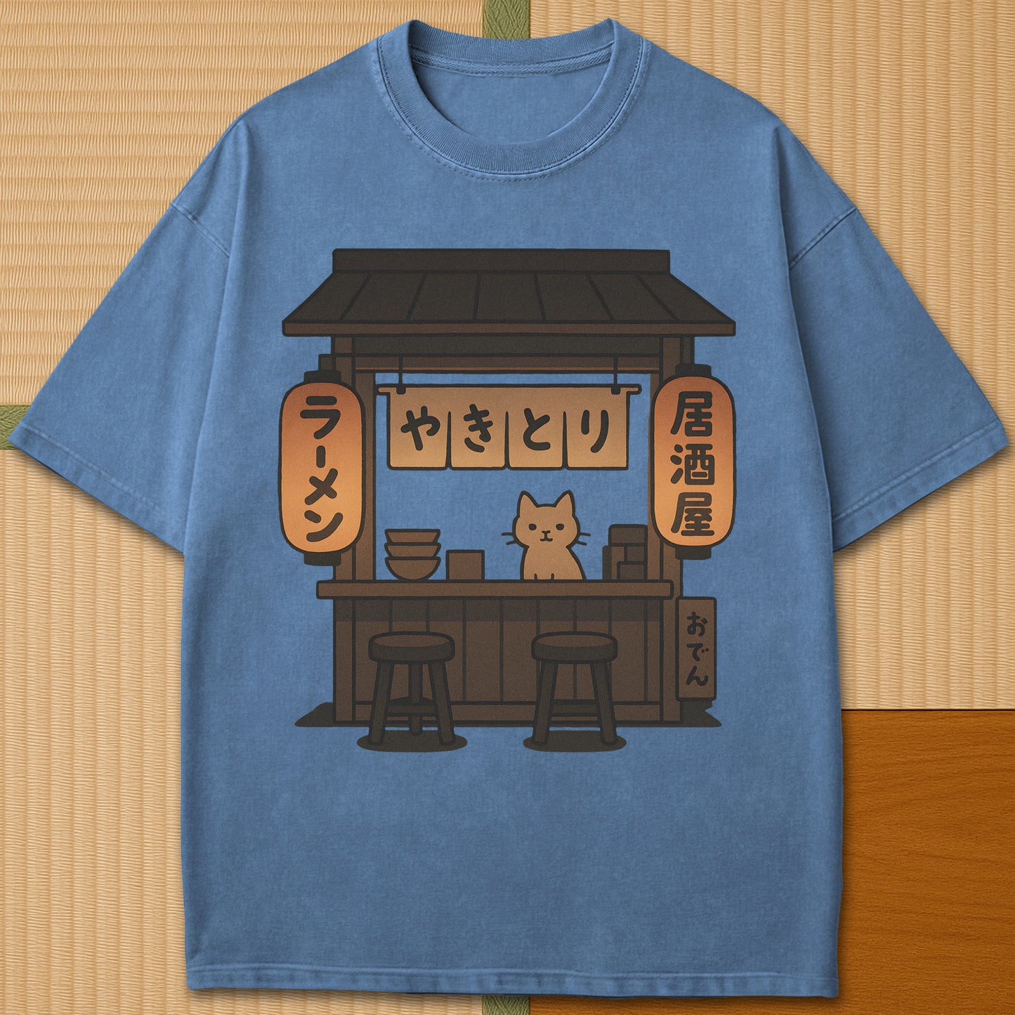 Japanese-inspired cotton Cozy Cat At Japanese Yatai T-Shirt in Blue Jean on Comfort Colors 1717, styled in a modern flatlay scene.